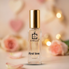 Perfume bottle labeled 'First Love' by CHELLA with a soft, blurred background featuring flowers and lights.