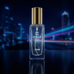 Chella perfume bottle with a gold cap on a reflective surface against a blurred cityscape background