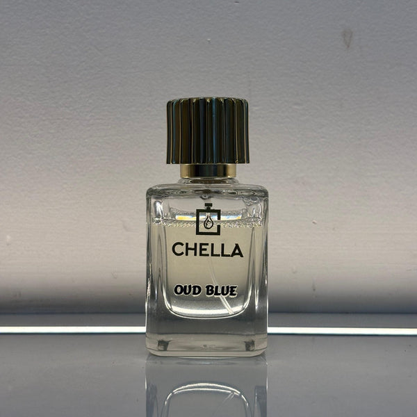 Clear perfume bottle labeled 'Chella Oud Blue' on a reflective surface with a neutral background