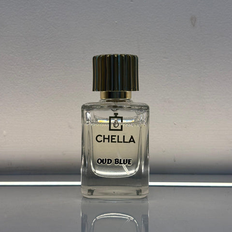 Clear perfume bottle labeled 'Chella Oud Blue' on a reflective surface with a neutral background