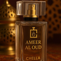 Perfume bottle labeled 'Ameer Al Oud Chella' on a textured surface with warm lighting.